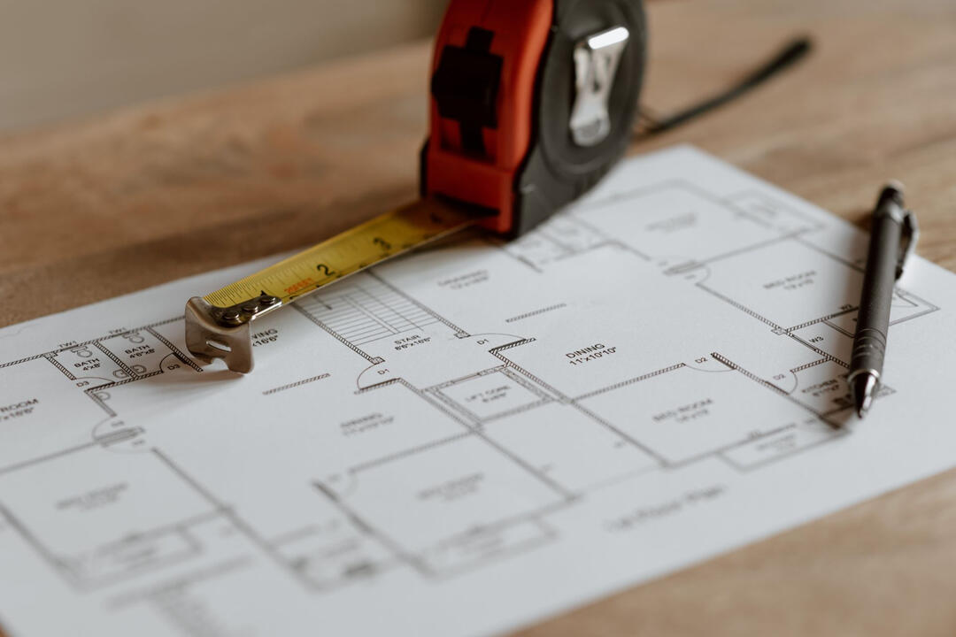 Get a Free Renovation Quote Sydney | Send Photos for a Custom Design House floor plan with a tape measure and pen, representing the process of submitting kitchen or bathroom photos for a free renovation quote and custom design consultation in Sydney.