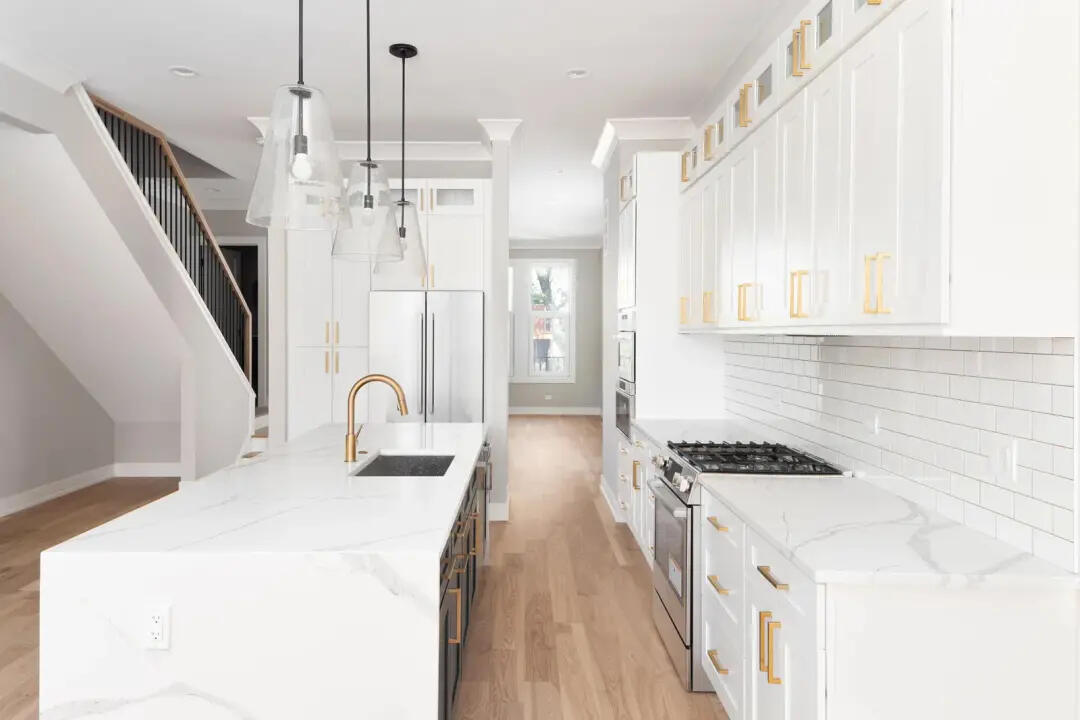 Sydney Renovation Reviews | Kitchen Renovation Success Stories Luxury kitchen renovation with white shaker cabinets, marble-look benchtops, gold fixtures, pendant lighting, and timber floors, representing highly rated kitchen renovation projects in Sydney.